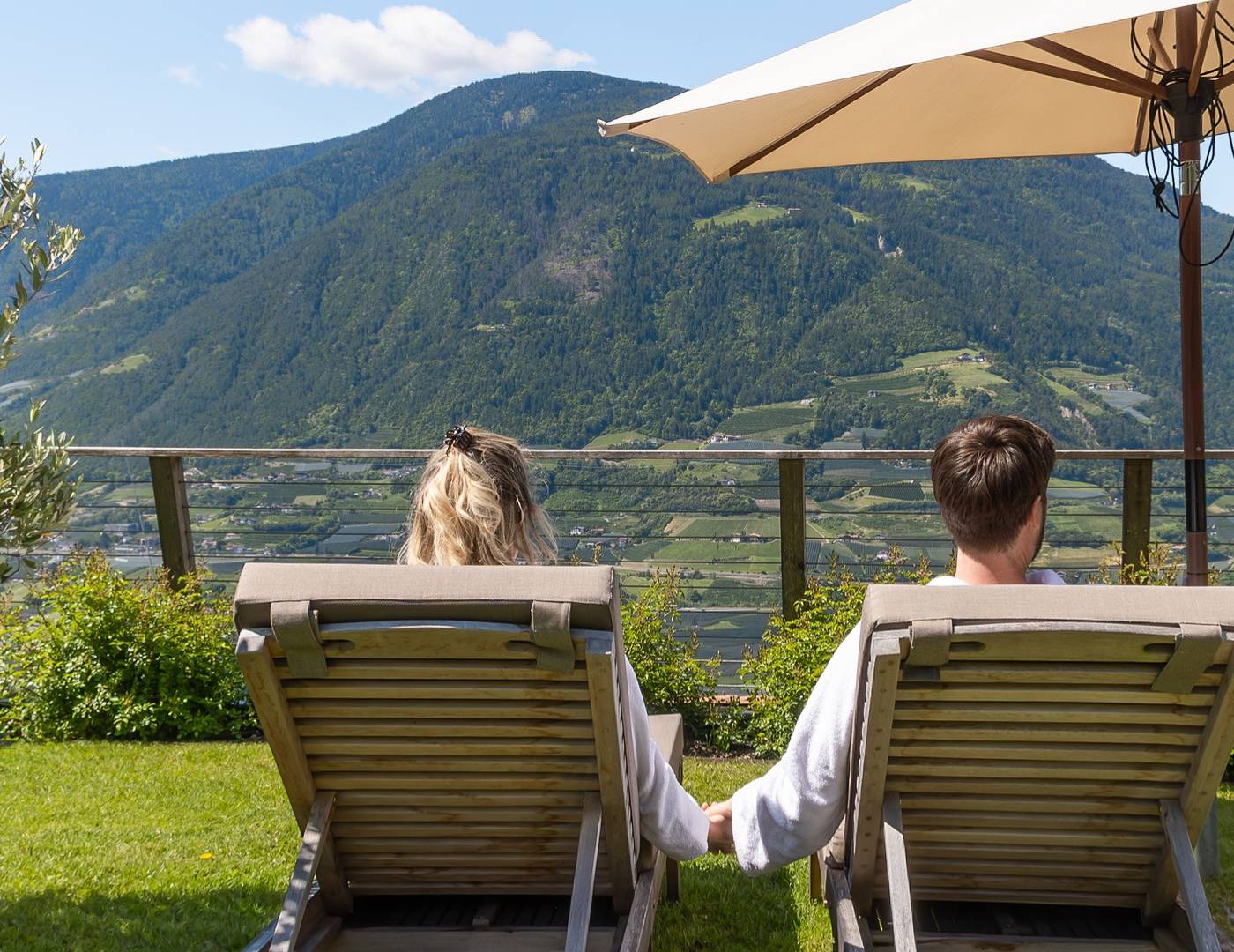Pärchen liegt Hand in Hand im Garten und genießt die Ruhe